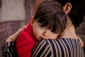 A touching scene of a mother tenderly holding her young son, showcasing love and closeness.